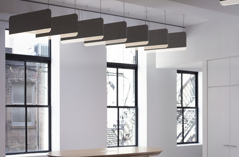The Work Bar near the pantry kitchen is a custom high table that allows teams to meet informally or have lunch together. It holds its own presence as an elegant, anchoring form while also referencing the shape of the ripples in the reception area ceiling. - Paul Warchol