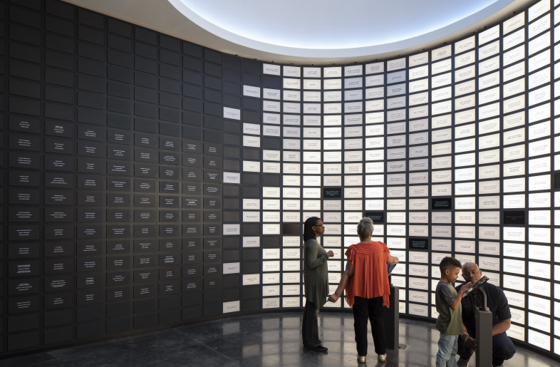 Commitment Space: Visitors end their journey by making a personal and actionable commitment toward racial reconciliation. An LED brick activates upon submission, adding visitors’ voices to the community wall of past commitments, which extends into a display of grassroots donor plaques. - Local Projects/ Mel Willis