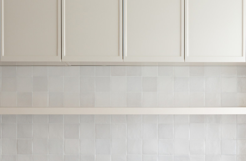 The handmade tiles match with the cupboard showing a warm texture under light. - Charles LV