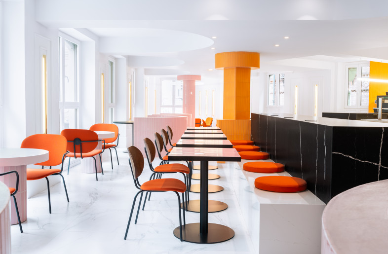 An interesting mix of low and high furniture creates different atmospheres, with round and square furniture that respects the geometry of the functional signage and is perfect for solo travelers or groups. - Caulin Photo