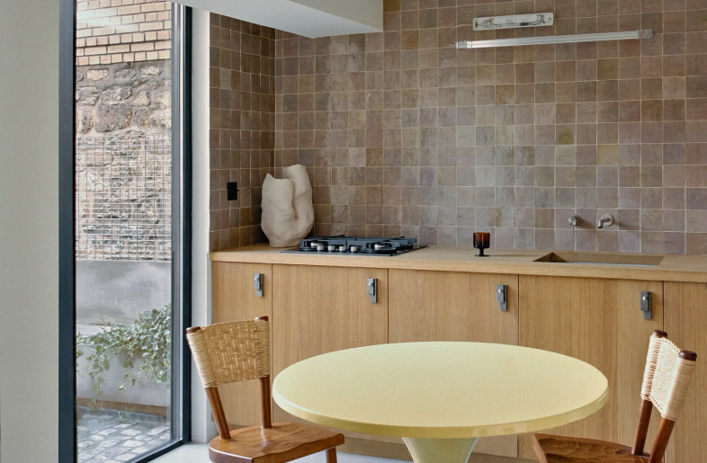 oak and wicker designer chairs by Marolles around a sherbet yellow table by Matti Suuronen, all reflected in a large wall size mirror - Christophe Coënon