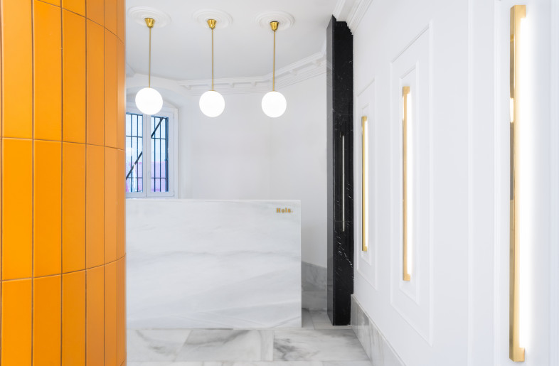 The new materiality comes from the building’s architecture itself: from its black and white marble; from its herringbone floors; from its colorful stained-glass windows and from the brass present in switches and other details of the building. - Caulin Photo