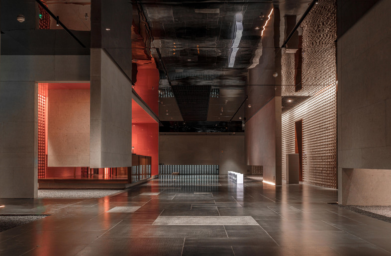 With interspersed gray and red walls, the waiting are and service desk are set up here. - Luo Wen & Zhong Yonggang