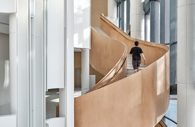 The lobby on the first floor and the entrance of the second floor are connected by a simple arc-shaped staircase, which appropriately follows the consistency of the space. - Jonathan Leijonhufvud Architectural Photography