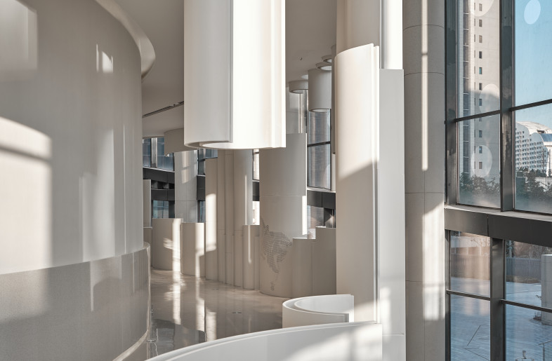 Natural light penetrates from the glass curtain walls of the building, and the light and shadow formed by the arc shapes appear on the floors and walls of the theater. - Jonathan Leijonhufvud Architectural Photography