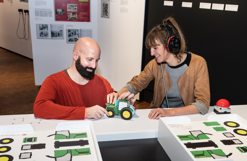 interactive station "assembly line, here visitors can listen to Foremen shouting orders in languages unknown to them, while assembling a cardboard tractor - Klaus Luginsland, TECHNOSEUM