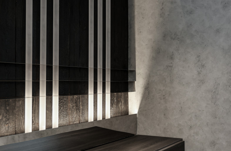Matte acrylic light tubes along the back wall of charred wood and mirror base sets a darker tone for the lounge area - Timmy Lo