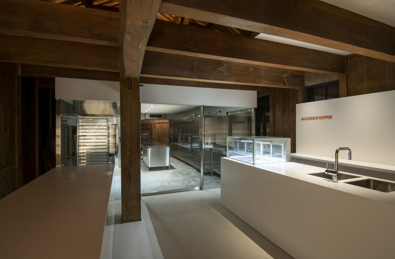 View from the café space to the laboratory. The lab space has a new wall in a setback position from the existing wall, creating an independent space in the storehouse as a box, without modifying the existing mud and board walls. - Hiroshi Mizusaki