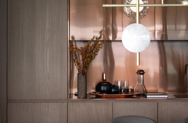 In the adjacent dining area, a rich copper bar creates a luminous glow adding warmth to the cool interior. - Mr. Edmon Leong