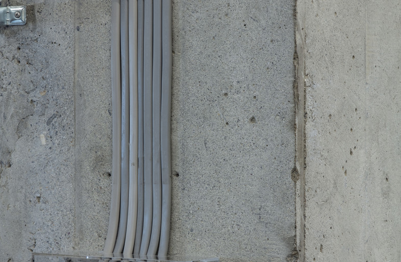 The exposed electrical wiring carefully laid out in the concrete walls is held in place using raw-edged leather. - Kenta Hasegawa