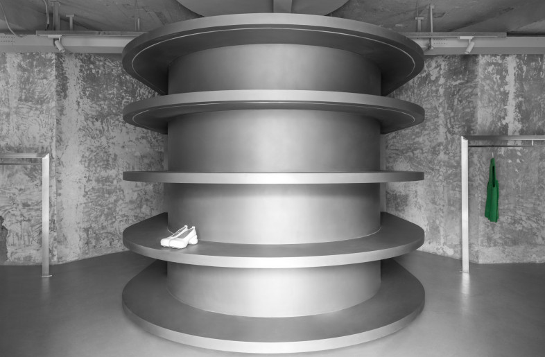 Based on the original building structure, the office area is parallel to the entrance of the store. The designer disposes floating circular arc-shaped laminates at the entrance. The interior is a functional block which takes into account the fitting room / live room. - Circular Shelves to the Entrance