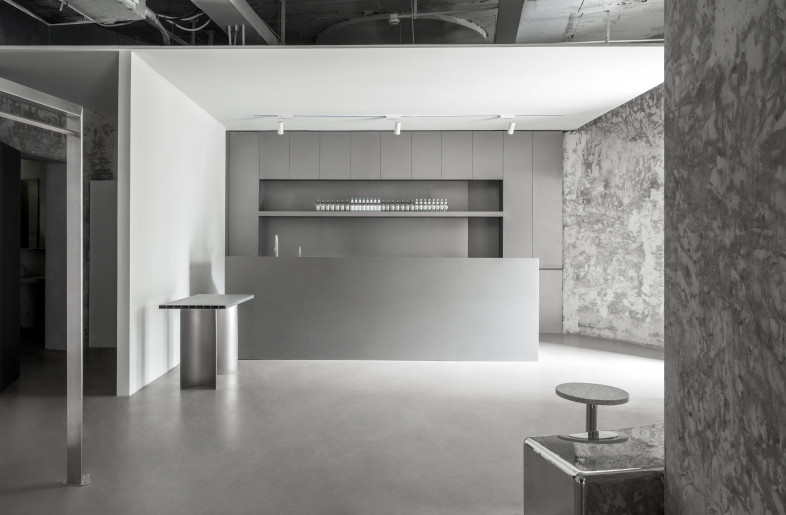 After entering the store, the bar area is on the right. The designer uses the simplest stainless steel square block to divide the space into two and separate the passageway leading to the bathroom. To the left is the clothing / Footwear display area. The designer uses the staircase between the two cylinders as a continuous space experience. - the bar