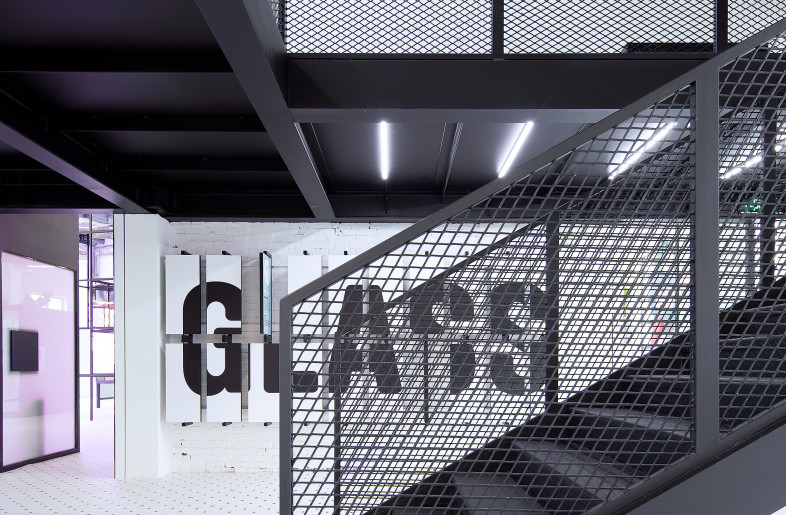 Black metal platforms and staircases are inserted into the open plan space to create layers. - COORDINATION ASIA